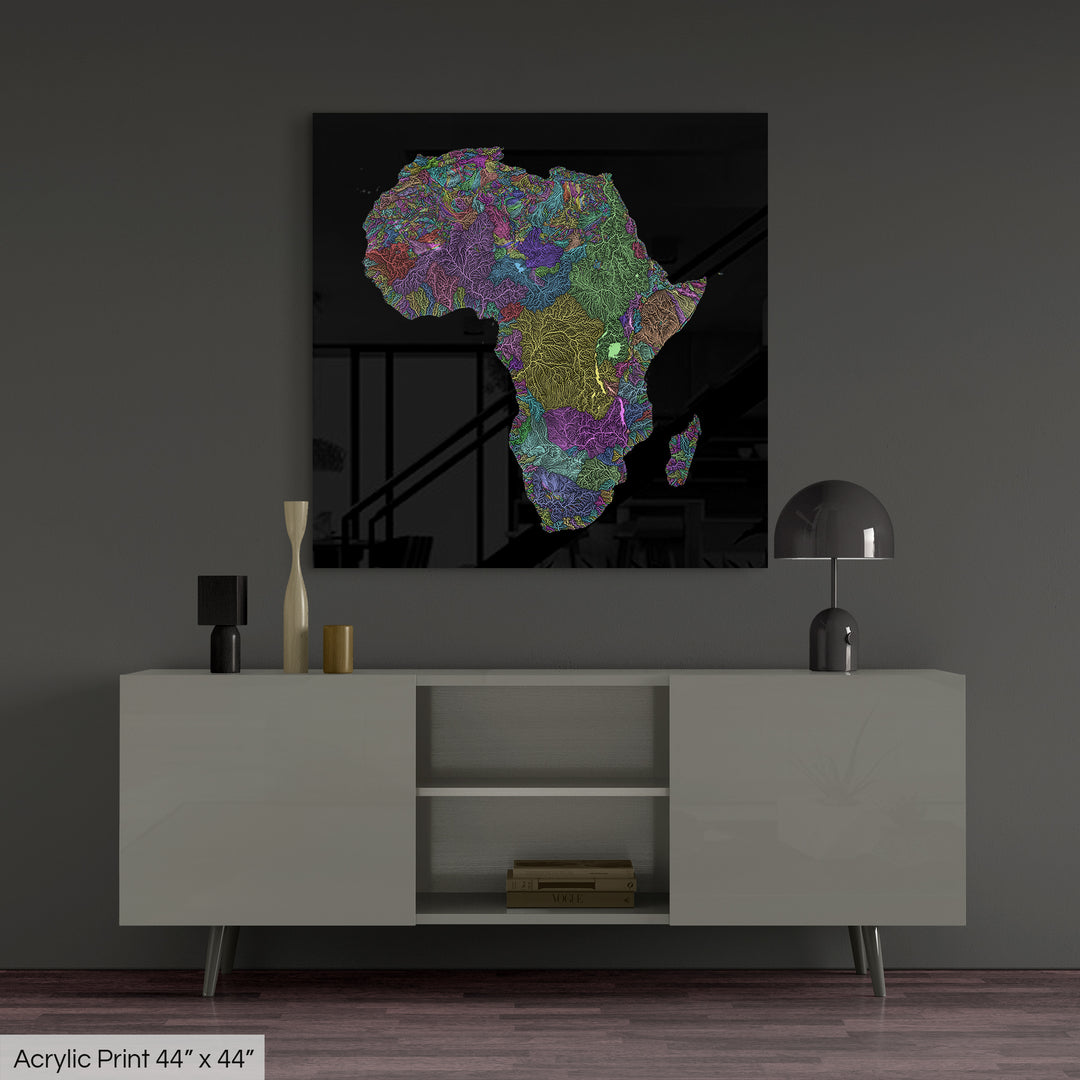 A colourful Grasshopper Geography map, home decor hanging on a grey wall in a living room. The map is printed on an acrylic panel and hangs above a modern low storage cabinet.