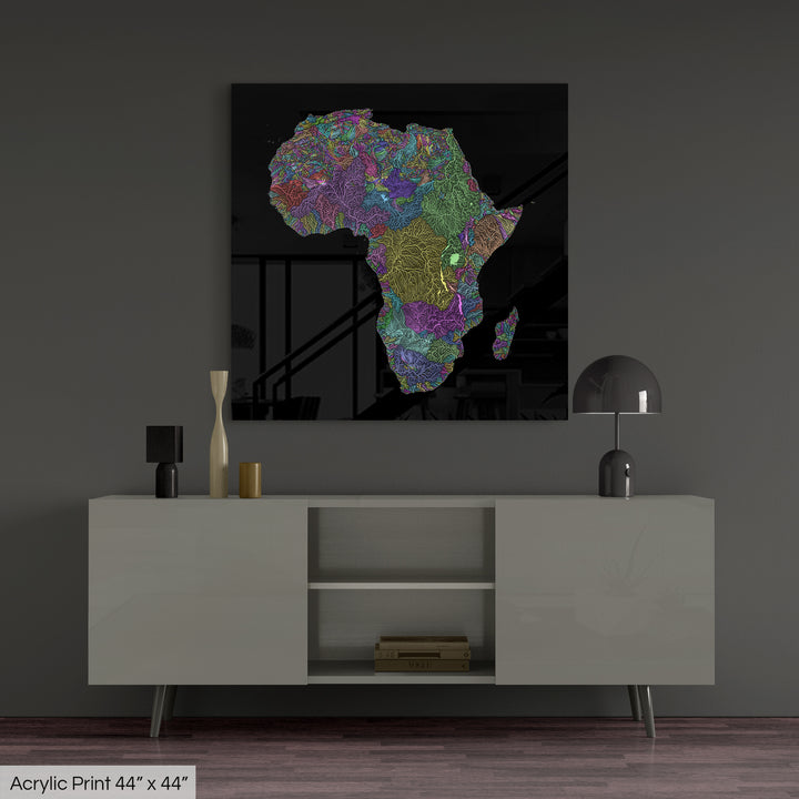 A colourful Grasshopper Geography map, home decor hanging on a grey wall in a living room. The map is printed on an acrylic panel and hangs above a modern low storage cabinet.