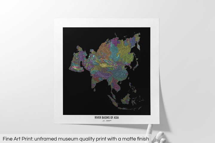 Unframed fine art print of a colourful map with a thick white mat. The title of the map and the Grasshopper Geography logo is printed on the mat, below the image. The map print lies flat on a white surface, a hand holding up one of the corners. The bottom text reads: Fine art print - unframed museum quality print with a matte finish.