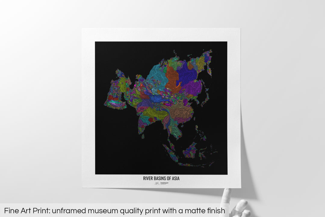 Unframed fine art print of a colourful map with a thick white mat. The title of the map and the Grasshopper Geography logo is printed on the mat, below the image. The map print lies flat on a white surface, a hand holding up one of the corners. The bottom text reads: Fine art print - unframed museum quality print with a matte finish.