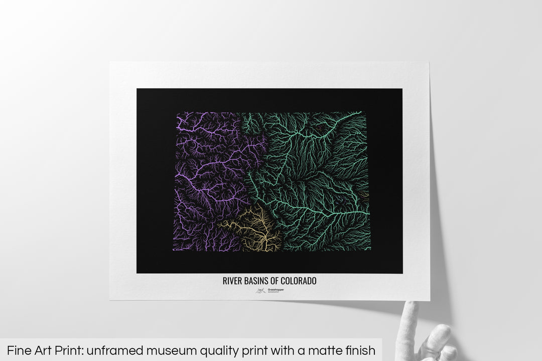 Unframed fine art print of a colourful map with a thick white mat. The title of the map and the Grasshopper Geography logo is printed on the mat, below the image. The map print lies flat on a white surface, a hand holding up one of the corners. The bottom text reads: Fine art print - unframed museum quality print with a matte finish.