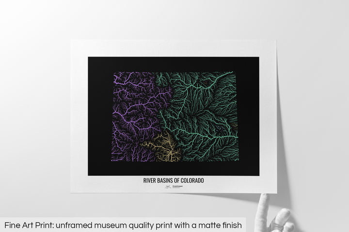 Unframed fine art print of a colourful map with a thick white mat. The title of the map and the Grasshopper Geography logo is printed on the mat, below the image. The map print lies flat on a white surface, a hand holding up one of the corners. The bottom text reads: Fine art print - unframed museum quality print with a matte finish.