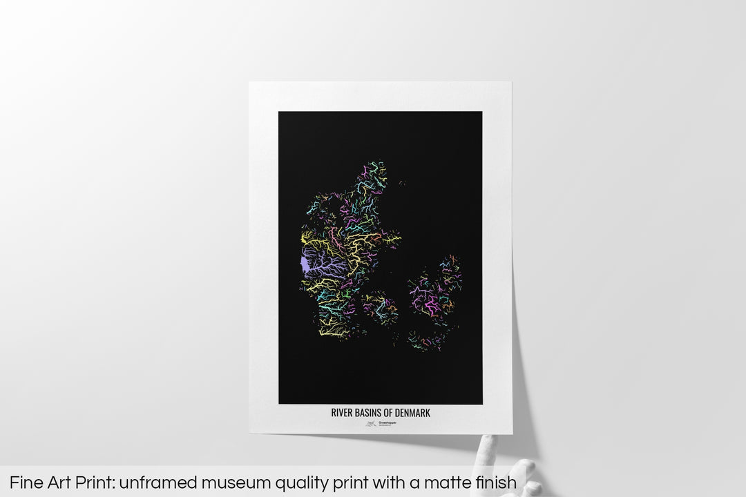 Unframed fine art print of a colourful map with a thick white mat. The title of the map and the Grasshopper Geography logo is printed on the mat, below the image. The map print lies flat on a white surface, a hand holding up one of the corners. The bottom text reads: Fine art print - unframed museum quality print with a matte finish.