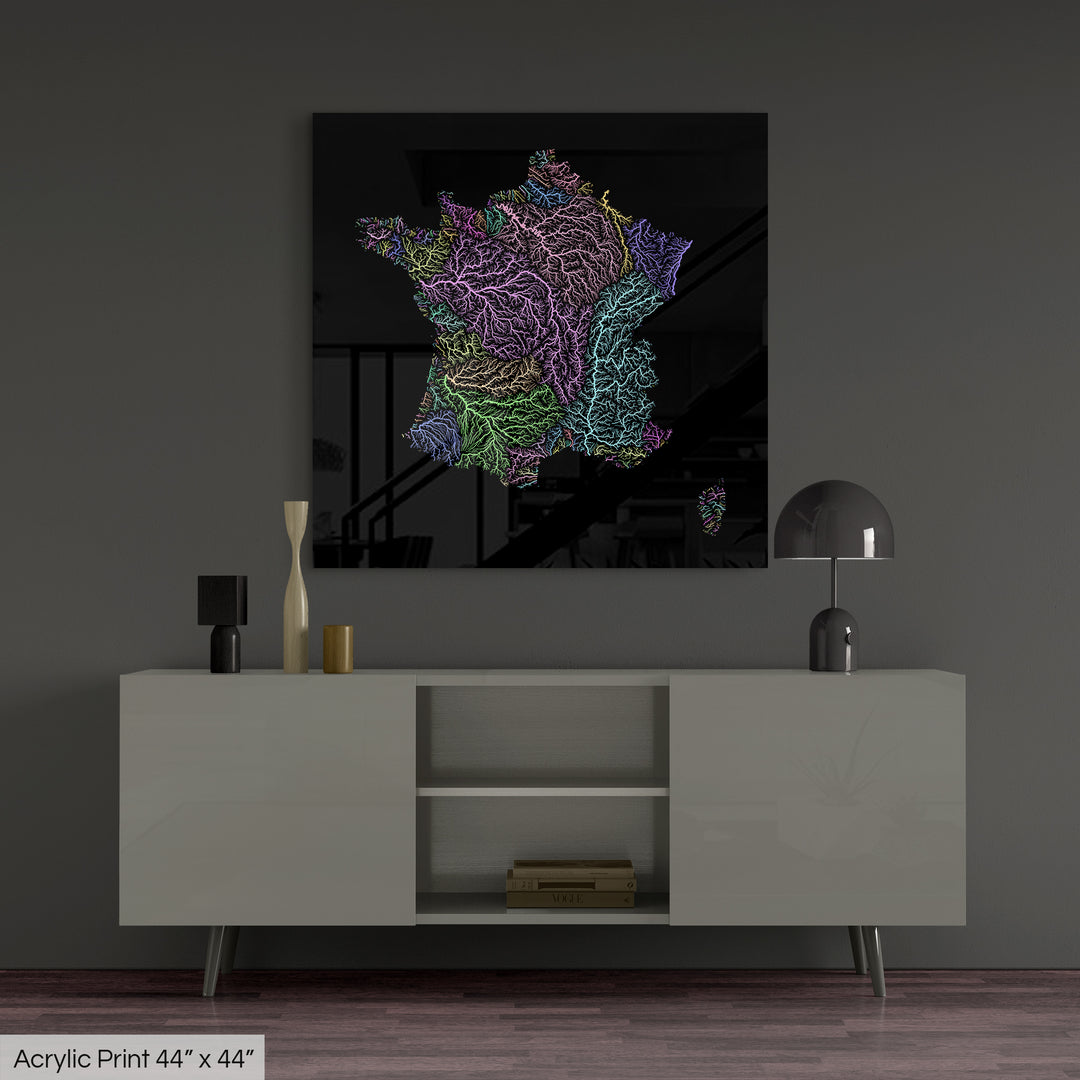 A colourful Grasshopper Geography map, home decor hanging on a grey wall in a living room. The map is printed on an acrylic panel and hangs above a modern low storage cabinet.