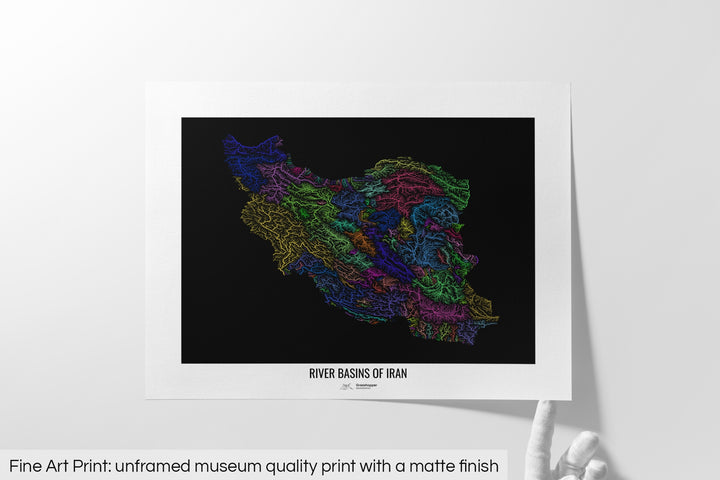 Unframed fine art print of a colourful map with a thick white mat. The title of the map and the Grasshopper Geography logo is printed on the mat, below the image. The map print lies flat on a white surface, a hand holding up one of the corners. The bottom text reads: Fine art print - unframed museum quality print with a matte finish.