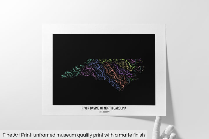 Unframed fine art print of a colourful map with a thick white mat. The title of the map and the Grasshopper Geography logo is printed on the mat, below the image. The map print lies flat on a white surface, a hand holding up one of the corners. The bottom text reads: Fine art print - unframed museum quality print with a matte finish.