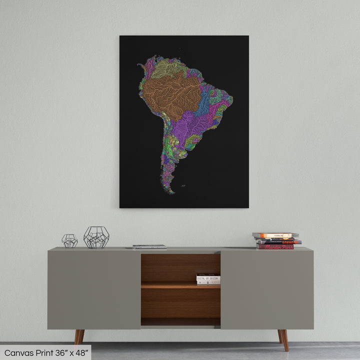 A colourful Grasshopper Geography map home decor in a living room, on a light grey wall. The map is printed on canvas and hangs above a modern low storage cabinet.