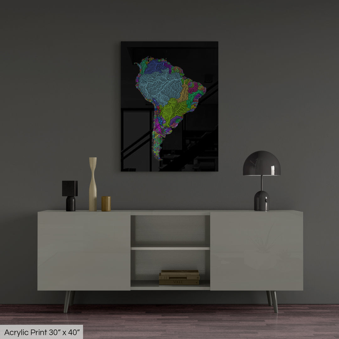 A colourful Grasshopper Geography map, home decor hanging on a grey wall in a living room. The map is printed on an acrylic panel and hangs above a modern low storage cabinet.