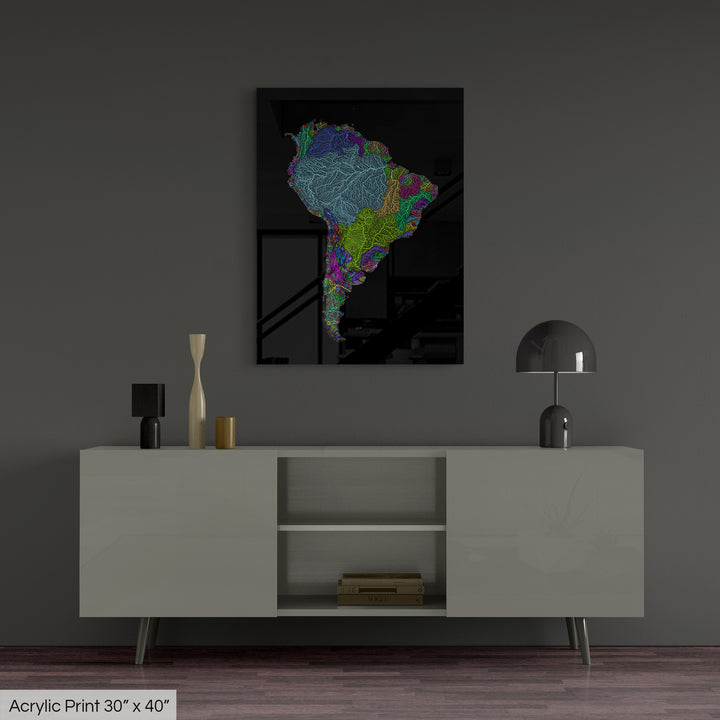 A colourful Grasshopper Geography map, home decor hanging on a grey wall in a living room. The map is printed on an acrylic panel and hangs above a modern low storage cabinet.