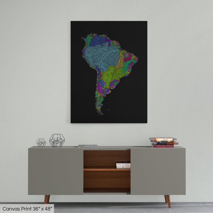 A colourful Grasshopper Geography map home decor in a living room, on a light grey wall. The map is printed on canvas and hangs above a modern low storage cabinet.