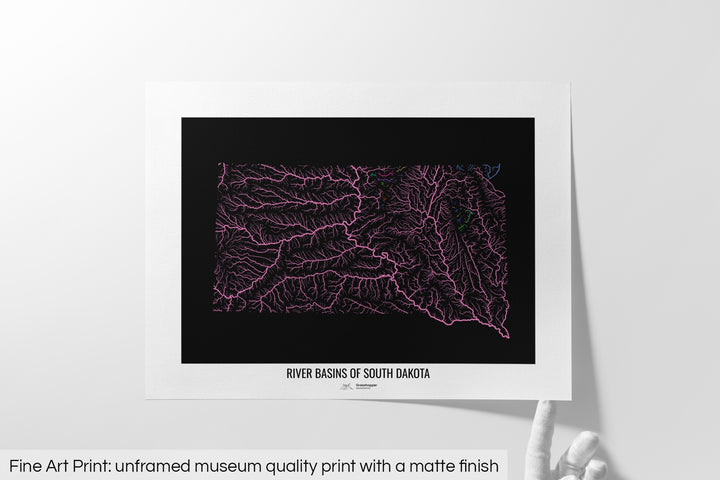 Unframed fine art print of a colourful map with a thick white mat. The title of the map and the Grasshopper Geography logo is printed on the mat, below the image. The map print lies flat on a white surface, a hand holding up one of the corners. The bottom text reads: Fine art print - unframed museum quality print with a matte finish.