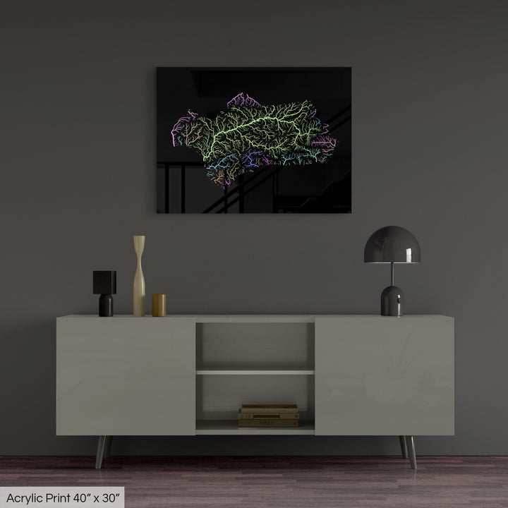 A colourful Grasshopper Geography map, home decor hanging on a grey wall in a living room. The map is printed on an acrylic panel and hangs above a modern low storage cabinet.