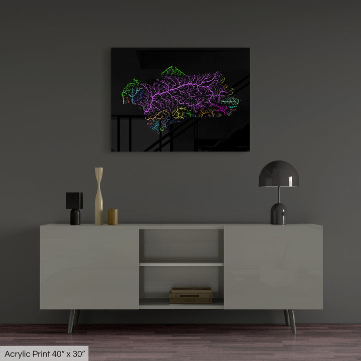 A colourful Grasshopper Geography map, home decor hanging on a grey wall in a living room. The map is printed on an acrylic panel and hangs above a modern low storage cabinet.