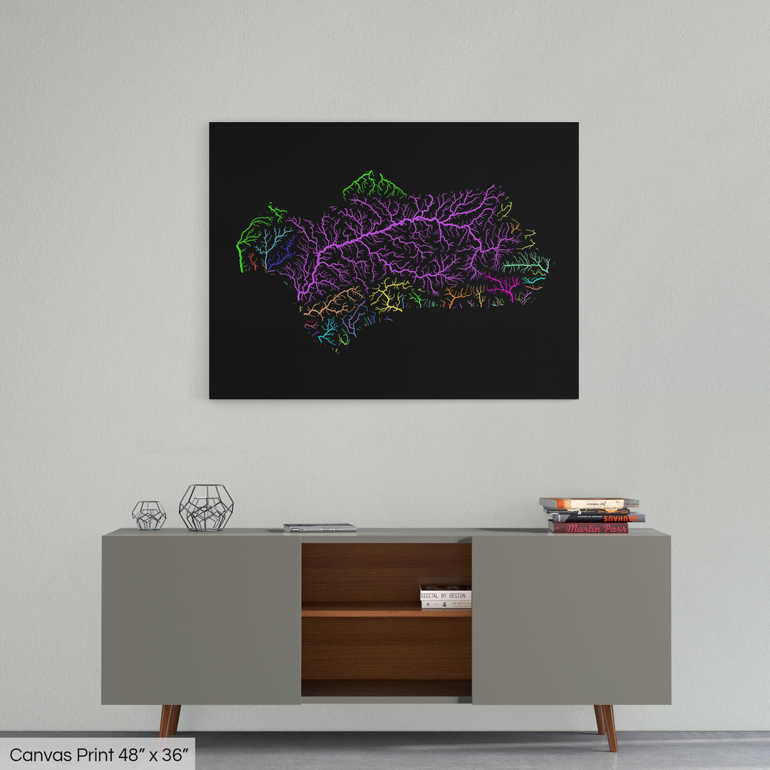 A colourful Grasshopper Geography map home decor in a living room, on a light grey wall. The map is printed on canvas and hangs above a modern low storage cabinet.