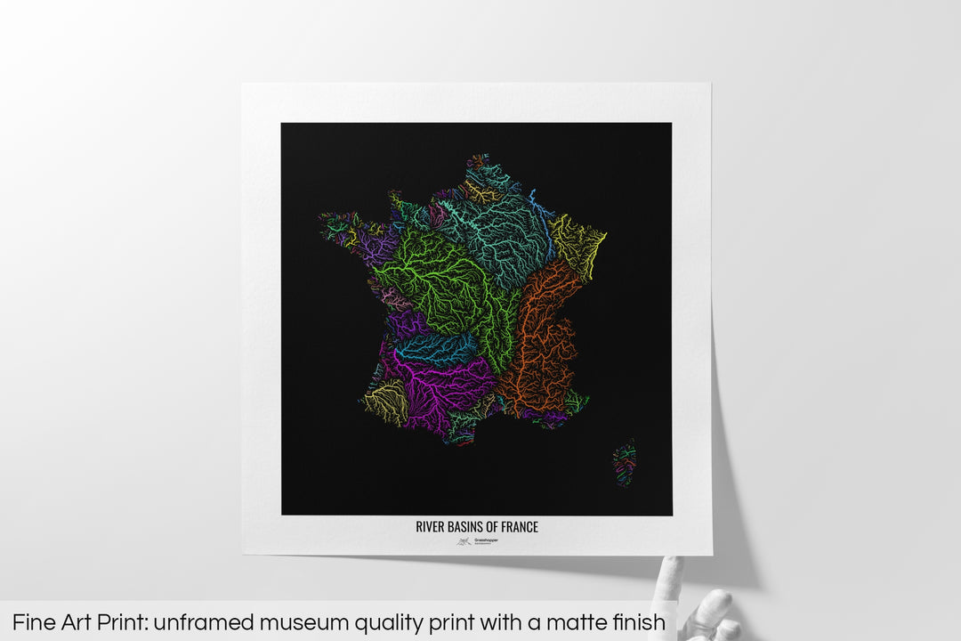 Unframed fine art print of a colourful map with a thick white mat. The title of the map and the Grasshopper Geography logo is printed on the mat, below the image. The map print lies flat on a white surface, a hand holding up one of the corners. The bottom text reads: Fine art print - unframed museum quality print with a matte finish.
