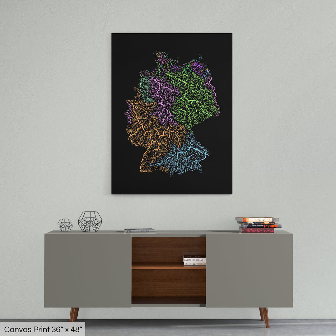 A colourful Grasshopper Geography map home decor in a living room, on a light grey wall. The map is printed on canvas and hangs above a modern low storage cabinet.