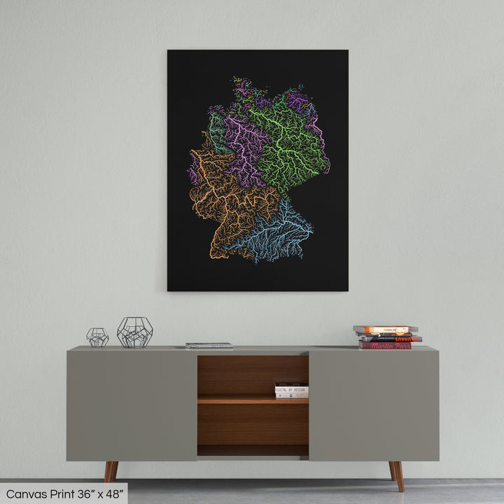 A colourful Grasshopper Geography map home decor in a living room, on a light grey wall. The map is printed on canvas and hangs above a modern low storage cabinet.