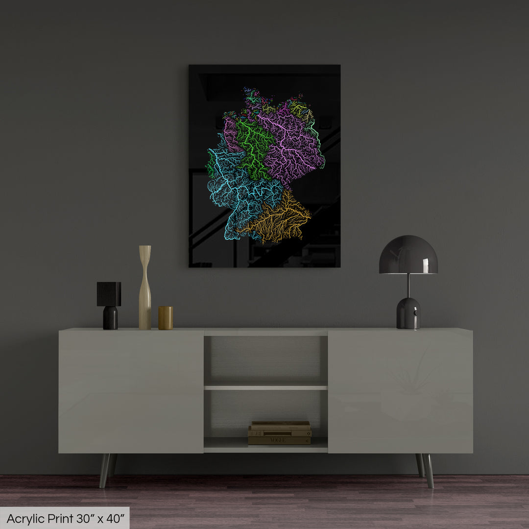 A colourful Grasshopper Geography map, home decor hanging on a grey wall in a living room. The map is printed on an acrylic panel and hangs above a modern low storage cabinet.