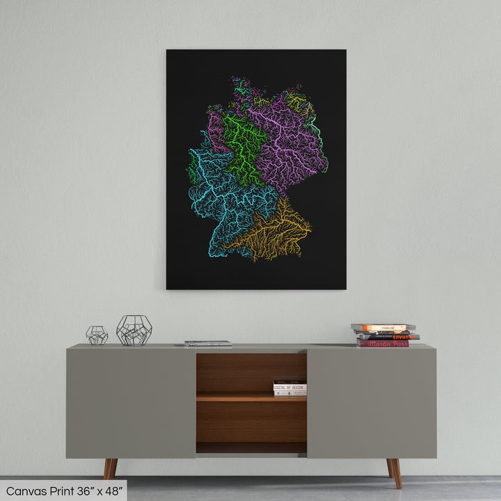 A colourful Grasshopper Geography map home decor in a living room, on a light grey wall. The map is printed on canvas and hangs above a modern low storage cabinet.