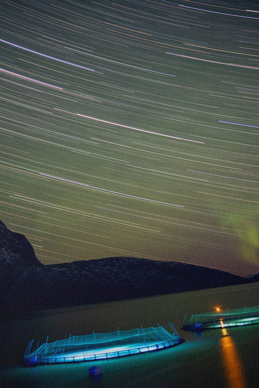Des traînées d'étoiles avec des aurores au-dessus des enclos à poissons I - Hahnemühle Photo Rag Print