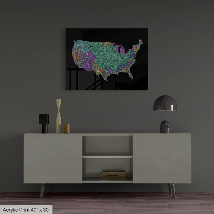 A colourful Grasshopper Geography map, home decor hanging on a grey wall in a living room. The map is printed on an acrylic panel and hangs above a modern low storage cabinet.
