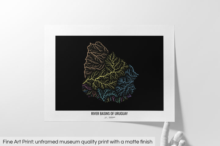 Unframed fine art print of a colourful map with a thick white mat. The title of the map and the Grasshopper Geography logo is printed on the mat, below the image. The map print lies flat on a white surface, a hand holding up one of the corners. The bottom text reads: Fine art print - unframed museum quality print with a matte finish.